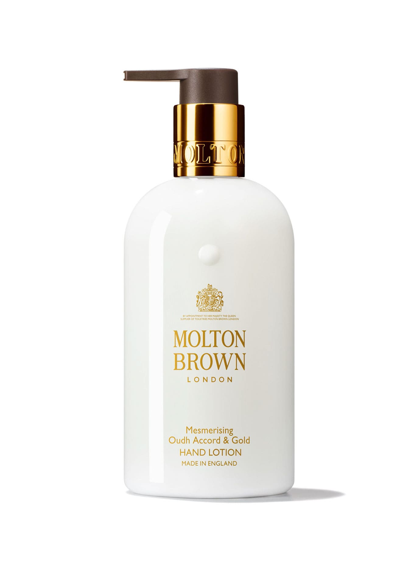 Botella elegante de la Loción de Manos Oudh Accord & Gold de Molton Brown en un entorno natural y sereno.